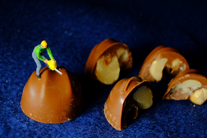 ミニチュア・ヒト写真、マカダミアナッツチョコレートを切る人